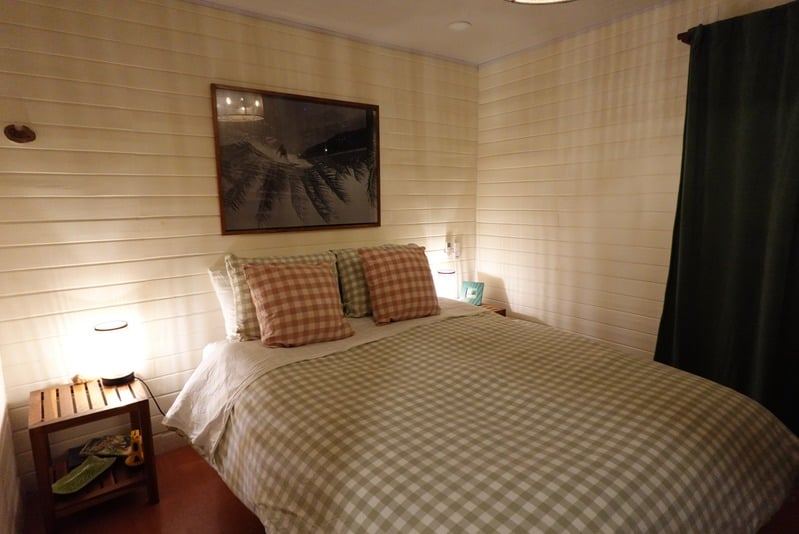 Bedroom with gingham bedding and framed surf print